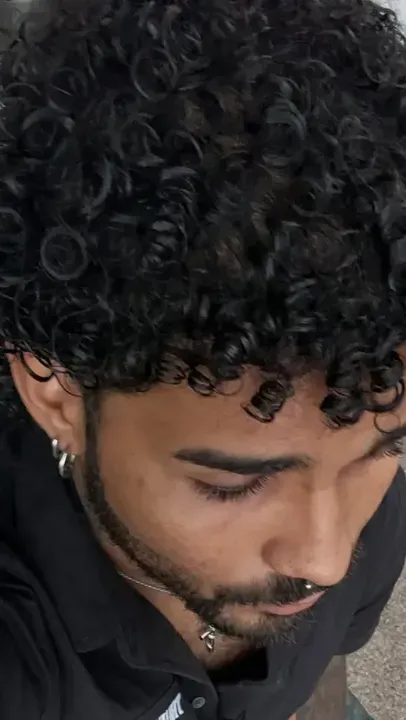 Yoru visto desde arriba, con el pelo rizado y una camisa negra
