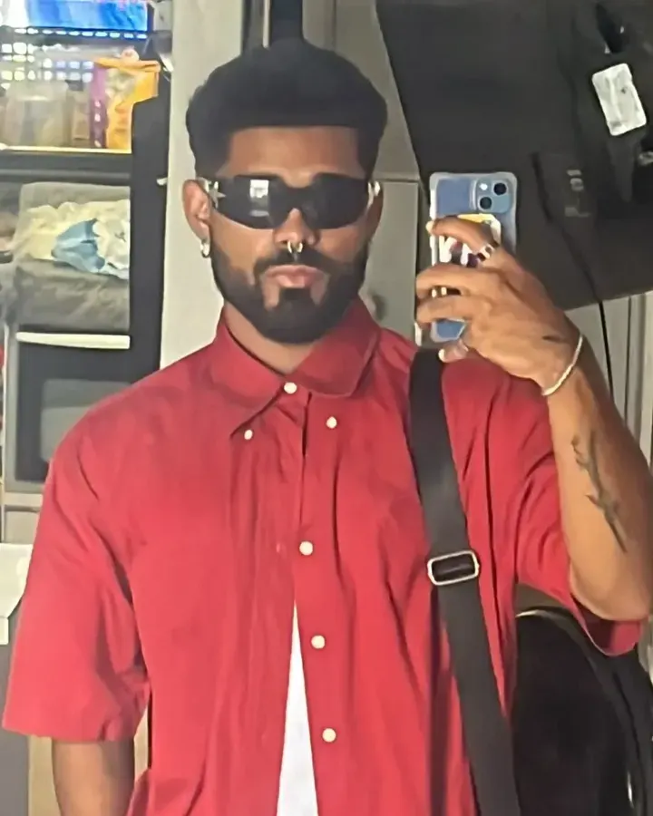 Yoru frente al espejo, con lentes oscuros y una camisa roja